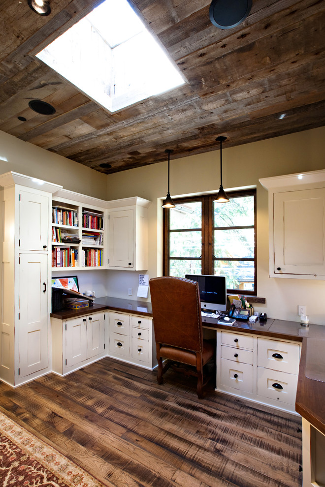 Rustik inredning av ett arbetsrum, med beige väggar och brunt golv