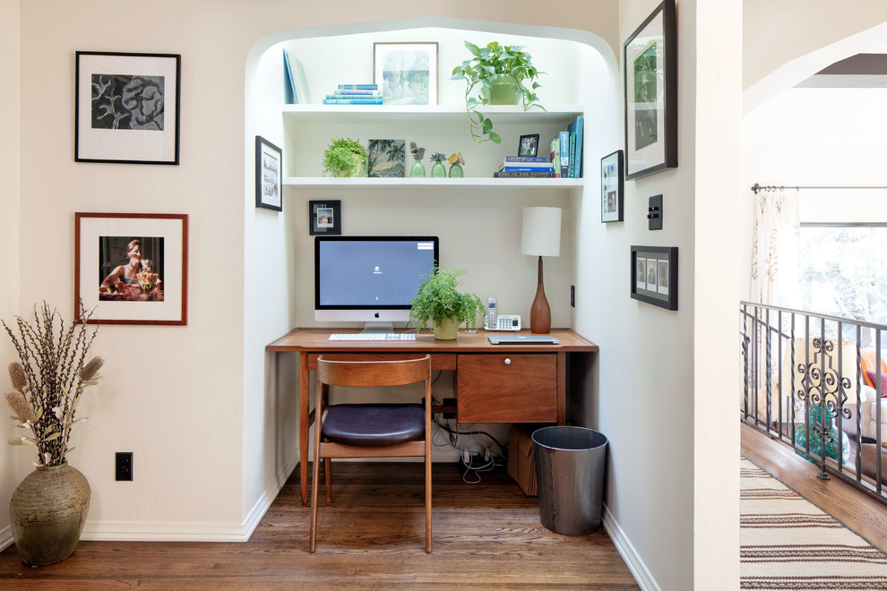 Mittelgroßes Mediterranes Arbeitszimmer mit beiger Wandfarbe, braunem Holzboden, Arbeitsplatz, Einbau-Schreibtisch und braunem Boden in Los Angeles