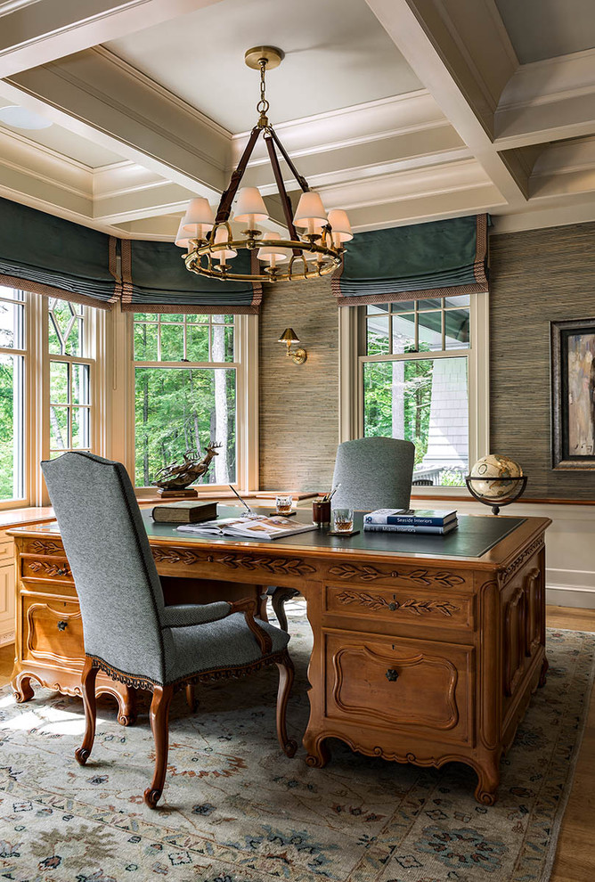 Modelo de despacho tradicional con paredes grises, suelo de madera en tonos medios, escritorio independiente y suelo marrón