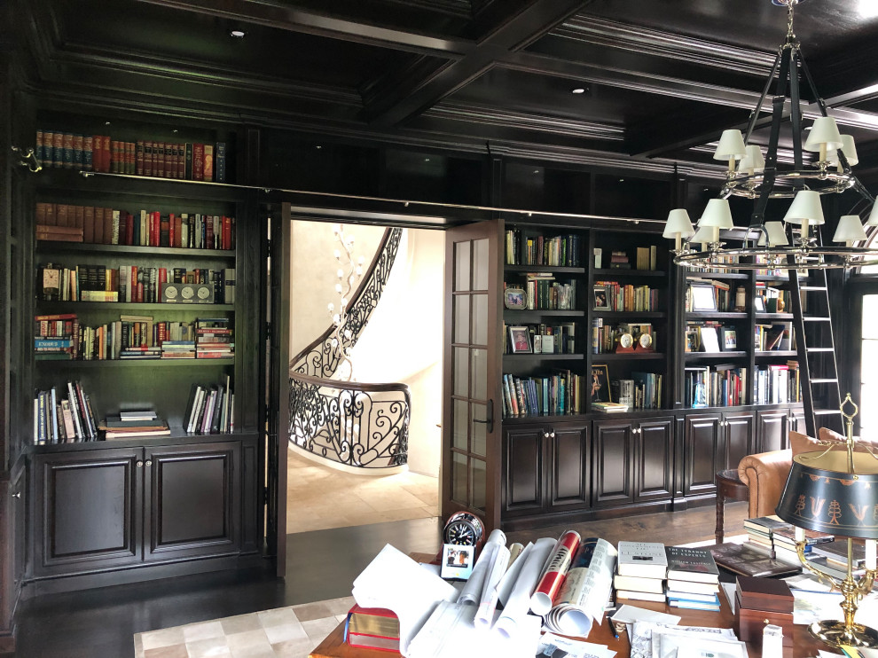 Стильный дизайн: огромный домашняя библиотека в классическом стиле с коричневыми стенами, темным паркетным полом, стандартным камином, фасадом камина из дерева, отдельно стоящим рабочим столом и коричневым полом - последний тренд