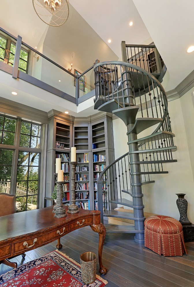 Inspiration för stora klassiska hemmabibliotek, med grå väggar, mellanmörkt trägolv, ett fristående skrivbord och brunt golv