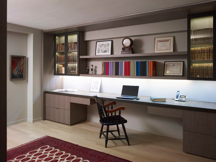 Foto på ett funkis hemmabibliotek, med grå väggar, ljust trägolv och ett inbyggt skrivbord