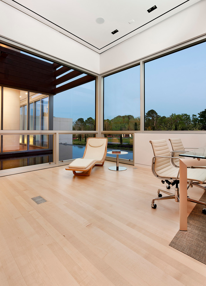 Ejemplo de despacho contemporáneo extra grande sin chimenea con paredes blancas, suelo de madera clara y escritorio independiente