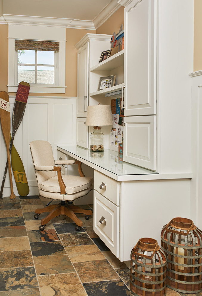 グランドラピッズにあるトラディショナルスタイルのおしゃれなホームオフィス・書斎 (ベージュの壁、セラミックタイルの床、造り付け机、マルチカラーの床、パネル壁) の写真