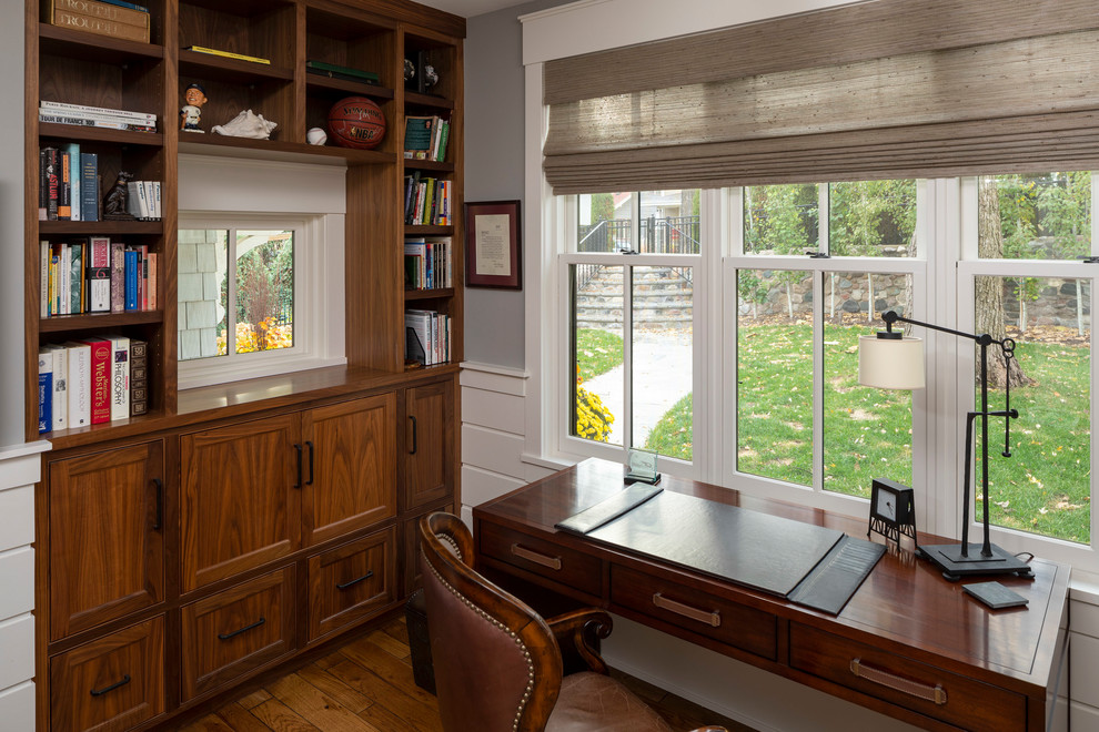 Cette photo montre un petit bureau chic avec un mur gris, parquet foncé, un bureau indépendant et un sol marron.