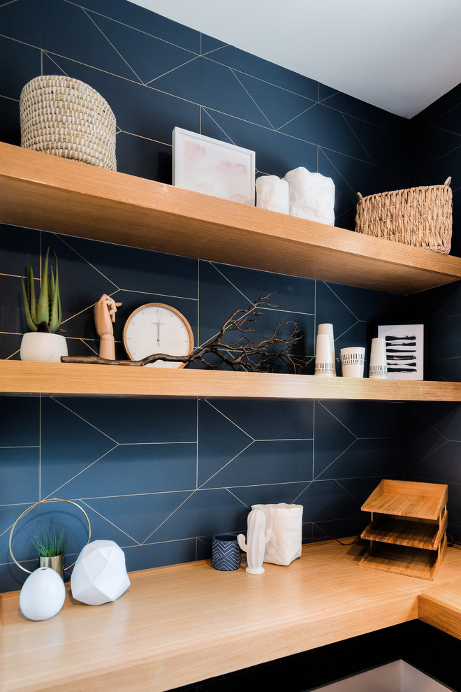 Foto på ett litet funkis arbetsrum, med blå väggar, ljust trägolv och ett inbyggt skrivbord