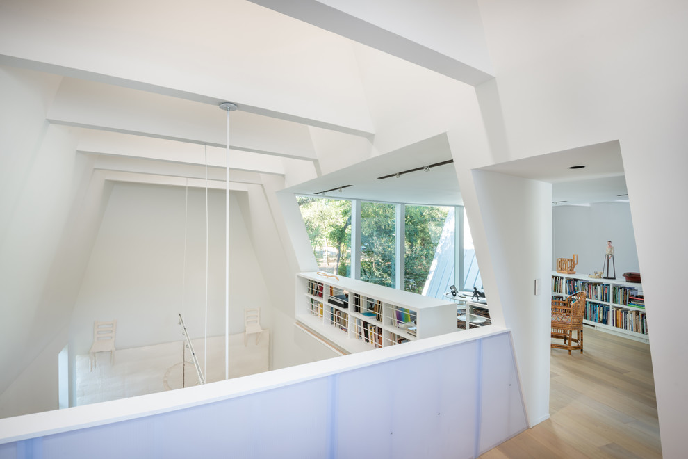 Example of a minimalist light wood floor study room design in Austin with white walls