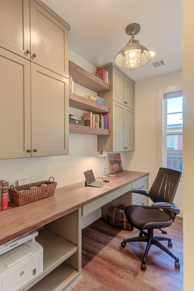Foto de despacho de estilo de casa de campo de tamaño medio con paredes blancas, suelo de madera oscura, escritorio empotrado y suelo marrón