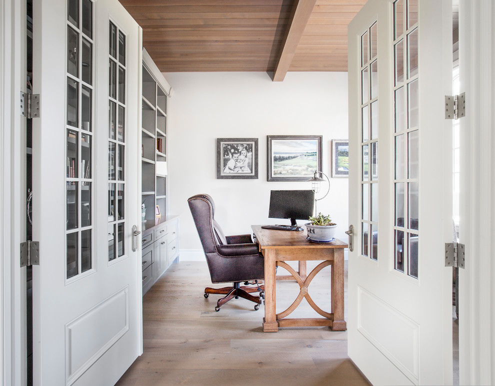 Foto på ett vintage arbetsrum, med vita väggar, ljust trägolv, ett fristående skrivbord och brunt golv