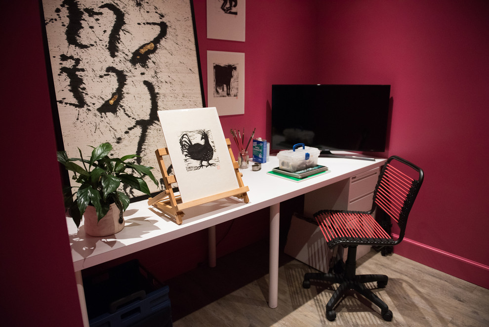 Exemple d'un bureau éclectique de taille moyenne et de type studio avec un mur rouge, parquet clair, aucune cheminée et un bureau indépendant.