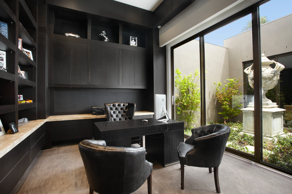 На фото: кабинет в современном стиле с черными стенами, ковровым покрытием и отдельно стоящим рабочим столом