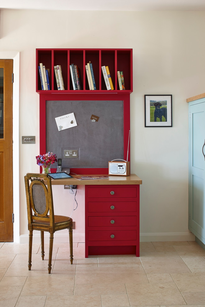 Example of a small farmhouse built-in desk limestone floor study room design in Surrey with white walls