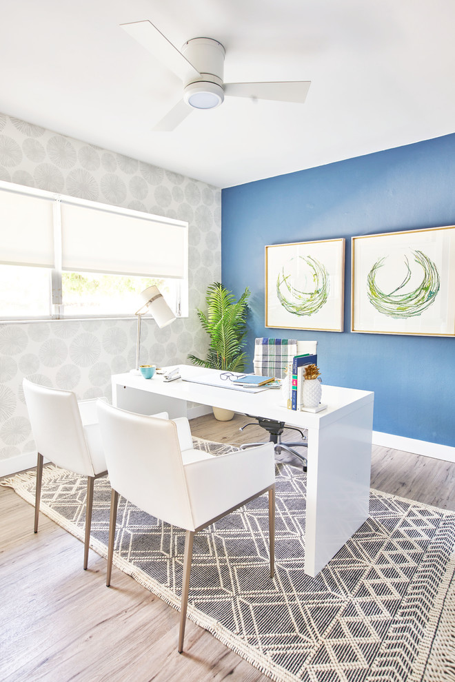 This is an example of a small contemporary study in Tampa with blue walls, vinyl flooring, a freestanding desk, grey floors and no fireplace.