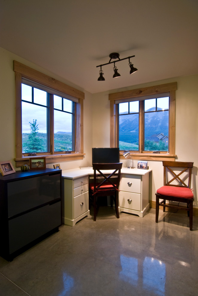 Small minimalist freestanding desk concrete floor home office photo in Denver with beige walls