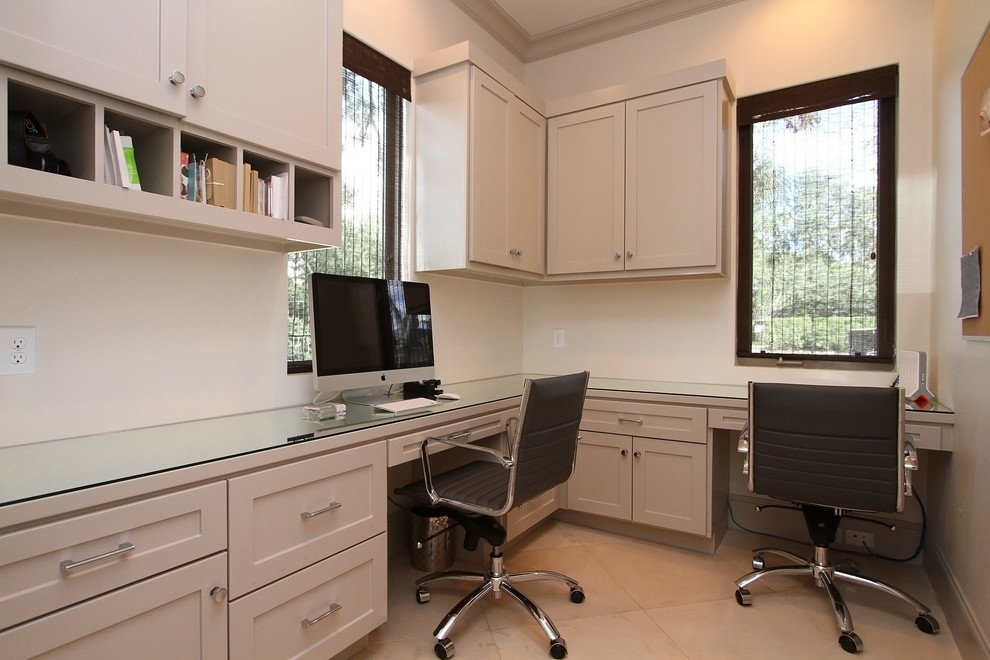 Ejemplo de sala de manualidades clásica renovada de tamaño medio con paredes grises, suelo de piedra caliza y escritorio empotrado