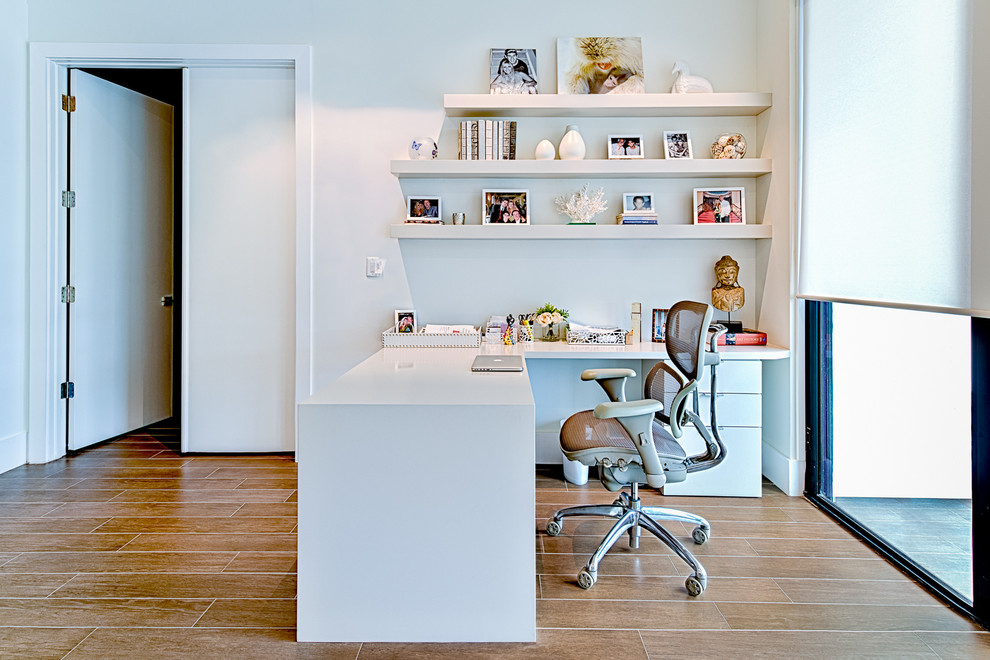 Mittelgroßes Modernes Arbeitszimmer mit Arbeitsplatz, weißer Wandfarbe, Porzellan-Bodenfliesen und freistehendem Schreibtisch in Miami