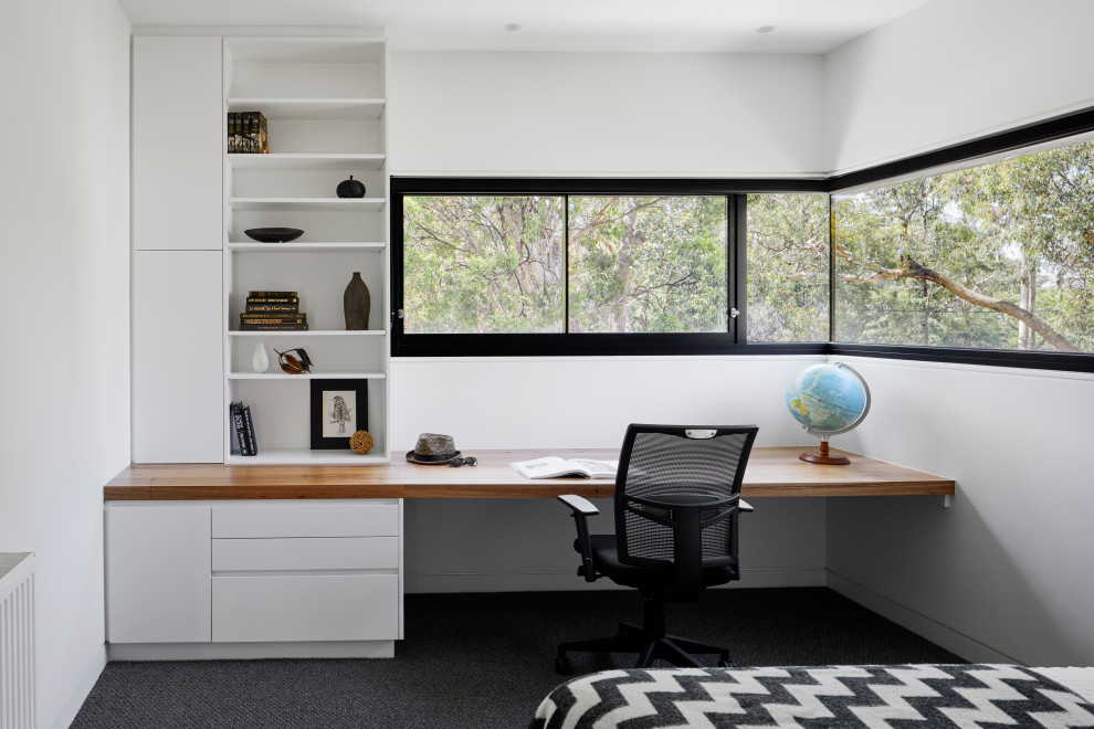 Medium sized contemporary study in Melbourne with white walls, carpet, a built-in desk and grey floors.