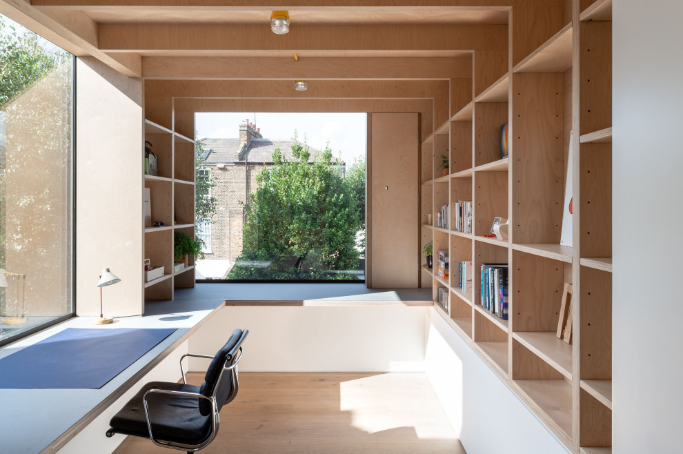 Modernes Arbeitszimmer mit Arbeitsplatz, hellem Holzboden, Einbau-Schreibtisch und beigem Boden in London