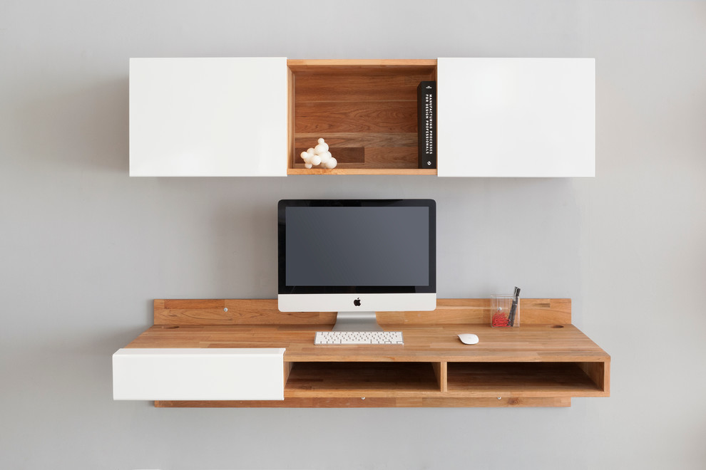 Modern inredning av ett litet arbetsrum, med grå väggar och ett inbyggt skrivbord