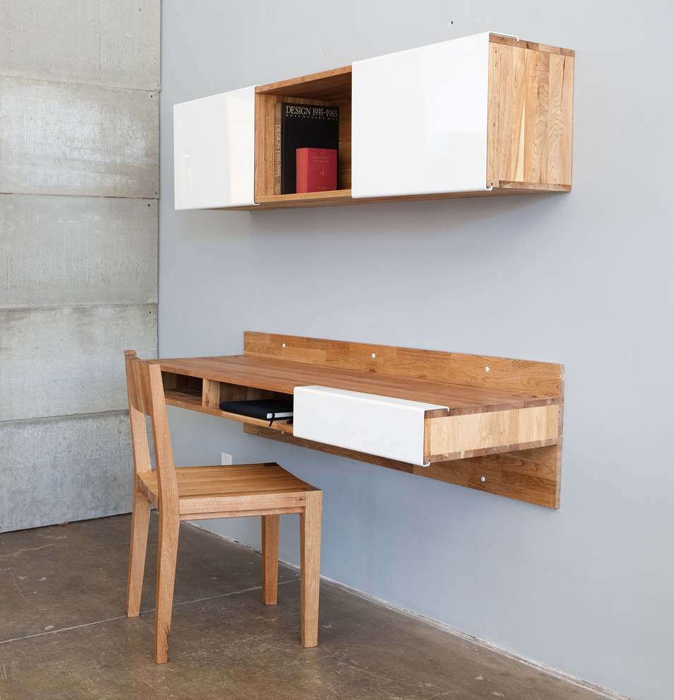 Study room - small modern built-in desk concrete floor study room idea in Los Angeles with gray walls