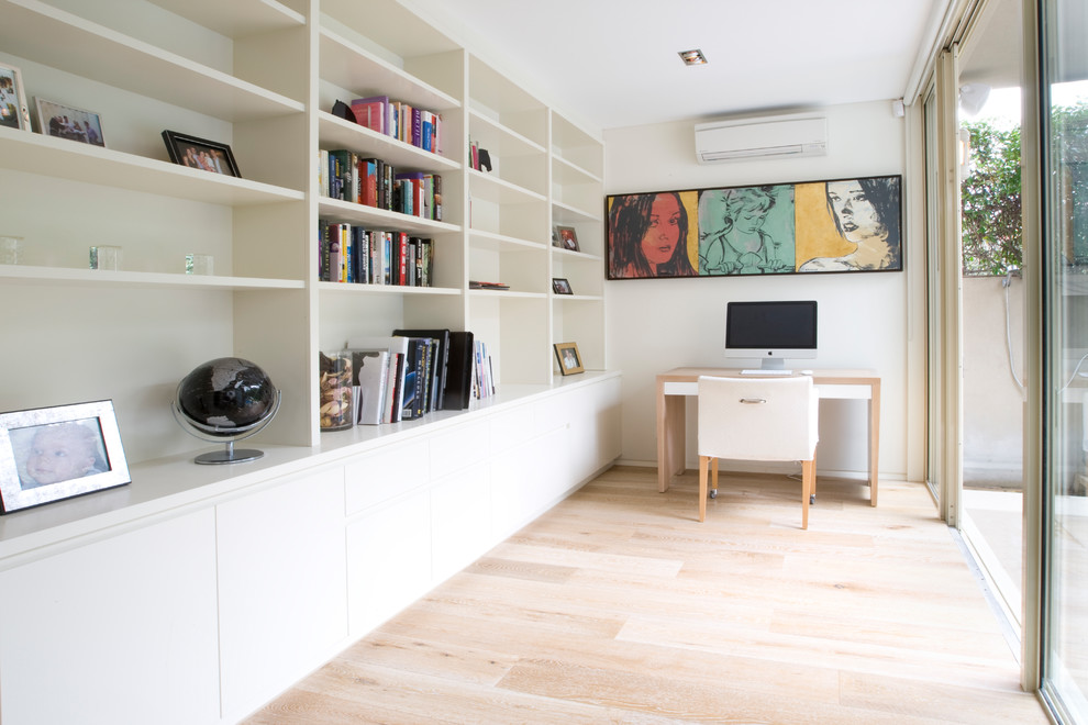 Modernes Arbeitszimmer mit Arbeitsplatz, weißer Wandfarbe, hellem Holzboden, freistehendem Schreibtisch und beigem Boden in Sydney