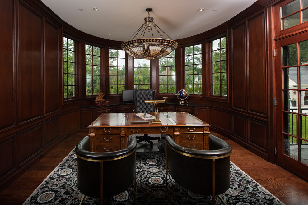 Foto de despacho clásico grande sin chimenea con paredes marrones, escritorio independiente, suelo marrón y suelo de madera oscura
