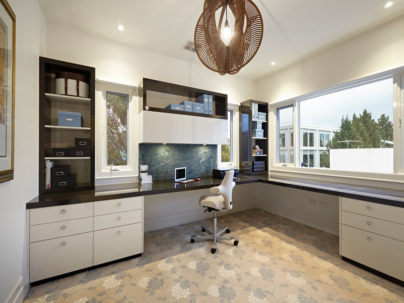Immagine di un ampio ufficio minimal con pareti beige, moquette, scrivania incassata e pavimento multicolore