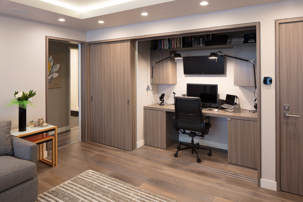 Imagen de despacho contemporáneo con suelo de madera clara y escritorio empotrado