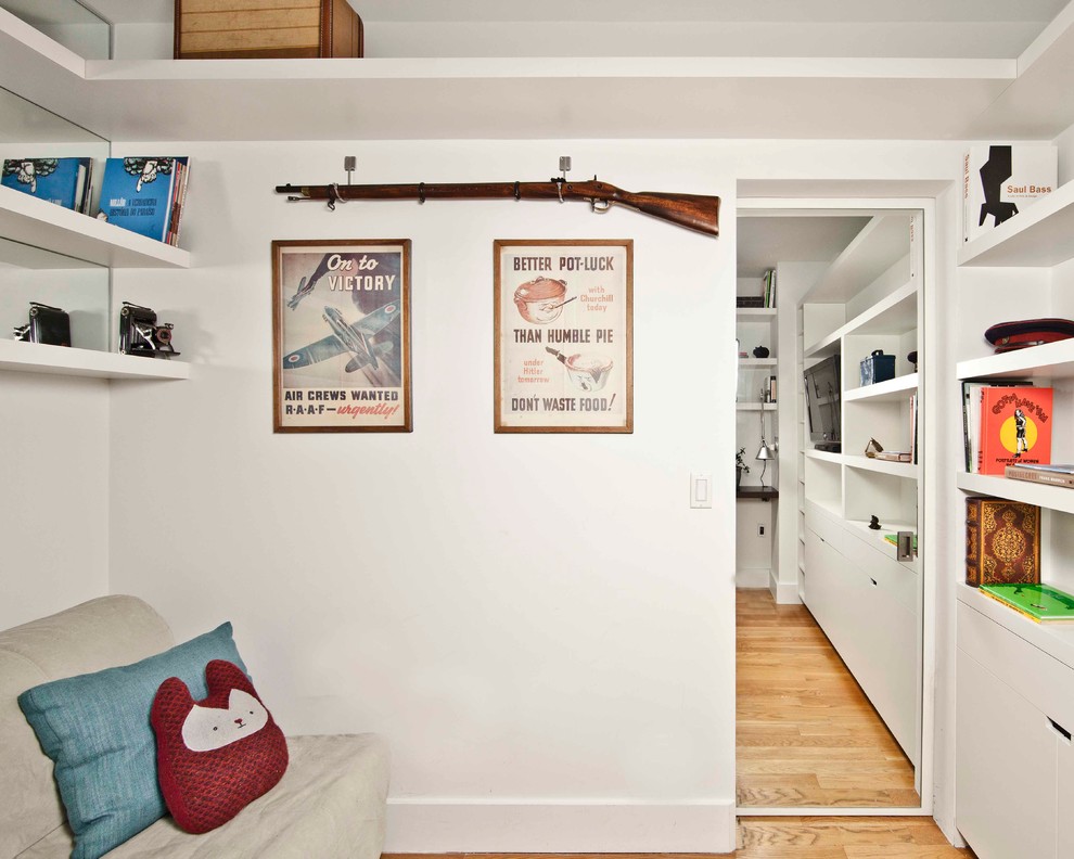 Immagine di uno studio minimal con pareti bianche e pavimento in legno massello medio