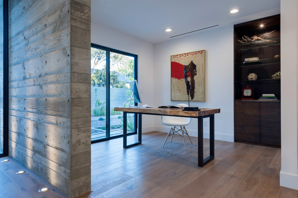 Mittelgroßes Modernes Arbeitszimmer ohne Kamin mit Arbeitsplatz, weißer Wandfarbe, hellem Holzboden, freistehendem Schreibtisch und braunem Boden in San Diego