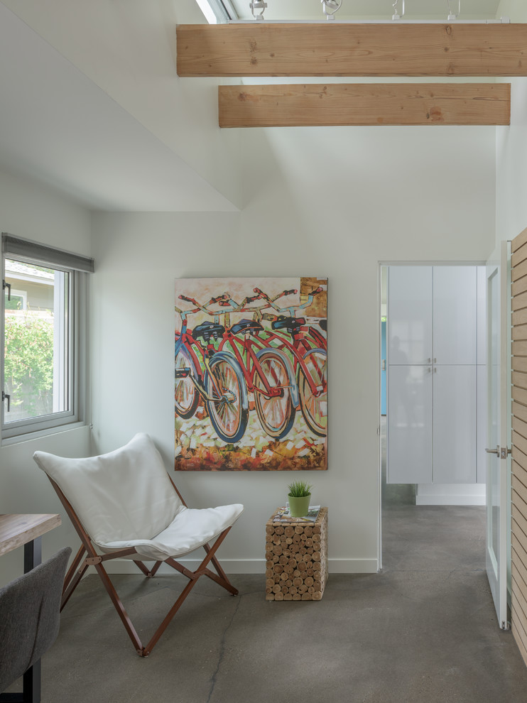 Inspiration för små moderna hemmastudior, med vita väggar, betonggolv, ett fristående skrivbord och grått golv