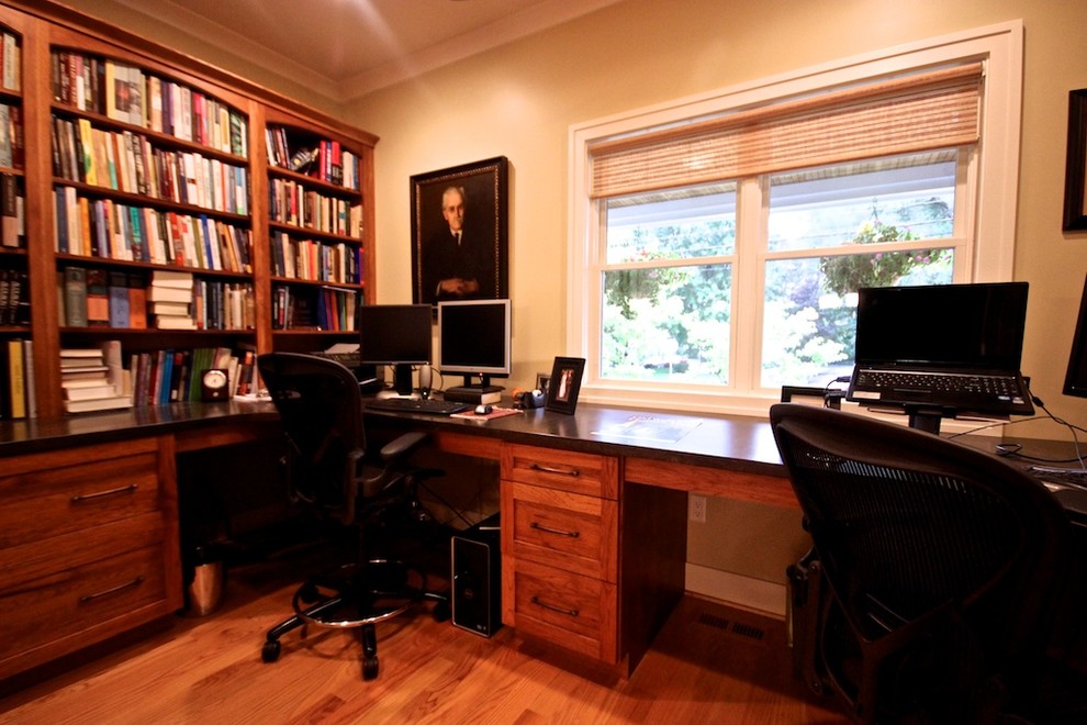 Idee per un piccolo ufficio american style con pareti beige, pavimento in legno massello medio, nessun camino, scrivania incassata e pavimento marrone