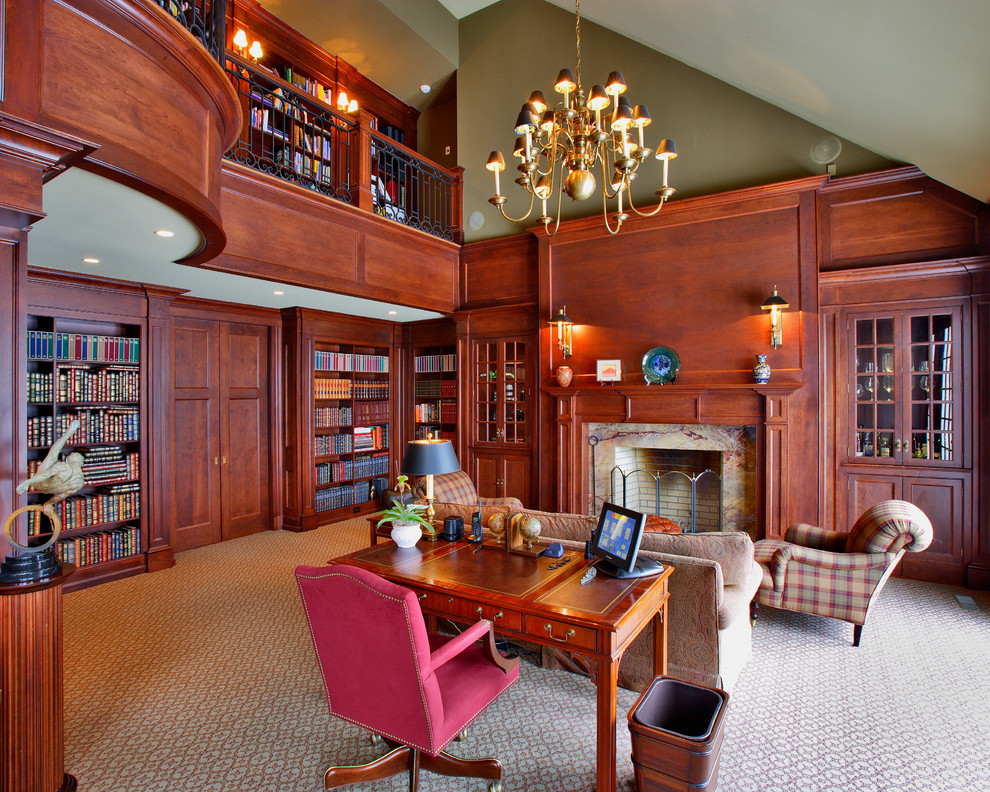 Inredning av ett klassiskt arbetsrum, med ett bibliotek, gröna väggar, heltäckningsmatta, en standard öppen spis och en spiselkrans i trä