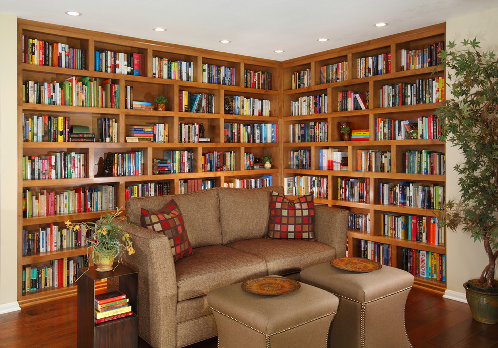 Inspiration för ett mellanstort amerikanskt arbetsrum, med ett bibliotek, bruna väggar, mörkt trägolv, brunt golv, en standard öppen spis och en spiselkrans i trä