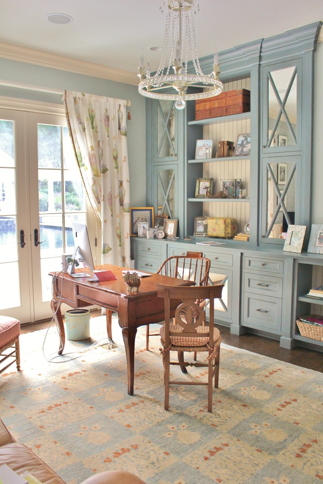 Ejemplo de despacho clásico con paredes azules, suelo de madera oscura y escritorio independiente