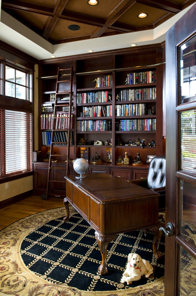 Ejemplo de despacho clásico con suelo de madera en tonos medios y escritorio independiente