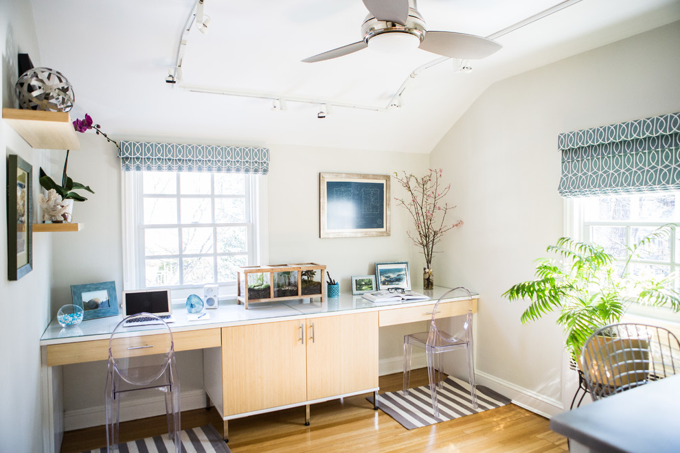 Example of a transitional built-in desk light wood floor study room design in New York with white walls