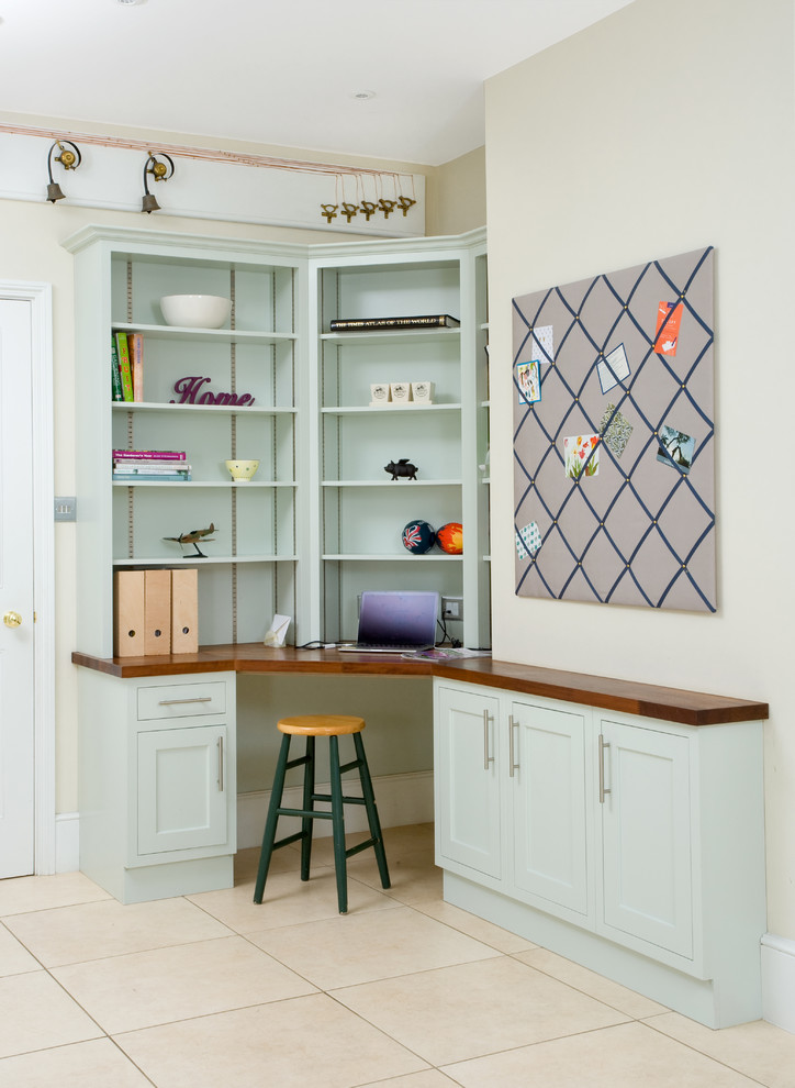 Diseño de despacho tradicional con paredes beige, escritorio empotrado y suelo beige