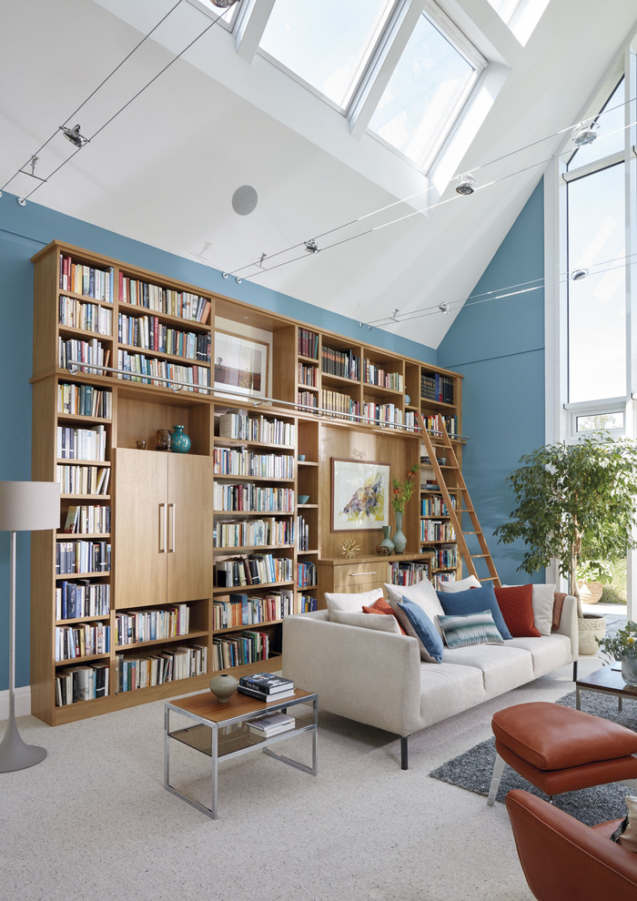 Esempio di un ampio studio tradizionale con libreria, pareti blu, moquette, scrivania incassata e pavimento beige