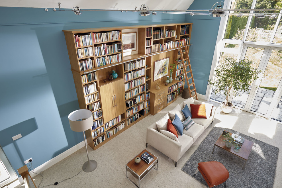 This is an example of an expansive traditional home office in Manchester with a reading nook, blue walls, carpet, a built-in desk and beige floors.