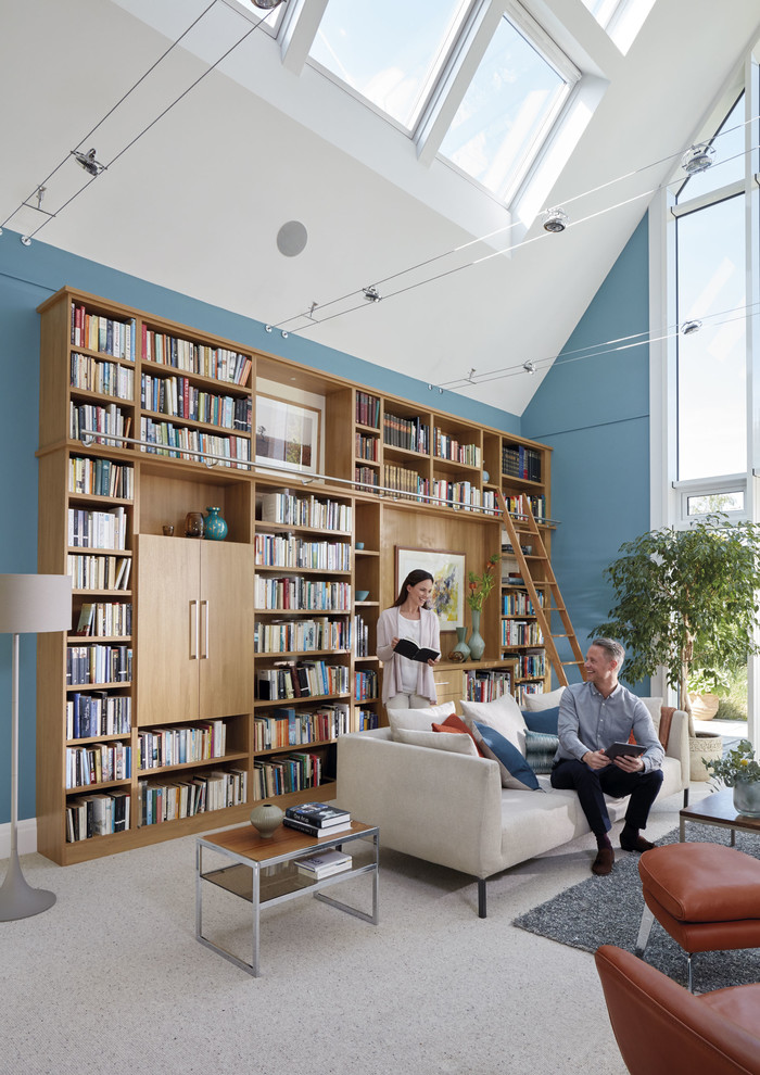 Modelo de despacho clásico extra grande con biblioteca, paredes azules, moqueta, escritorio empotrado y suelo beige
