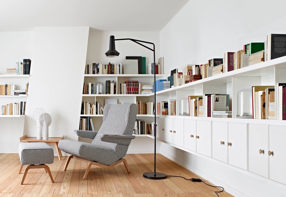 Esempio di uno studio minimalista con libreria, pareti bianche e parquet chiaro