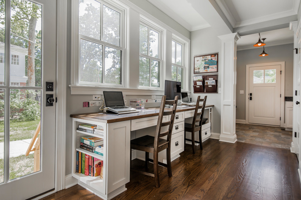 Cette photo montre un bureau chic avec un mur gris, parquet foncé, un bureau intégré et un sol marron.
