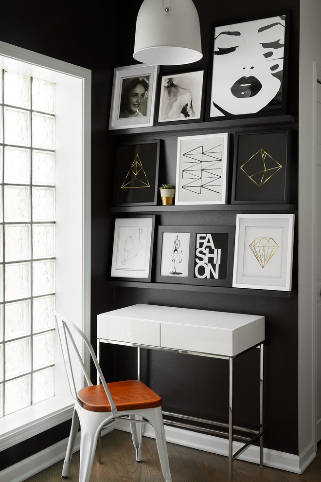 Modelo de despacho contemporáneo pequeño sin chimenea con paredes negras, suelo de madera oscura, escritorio independiente y suelo marrón