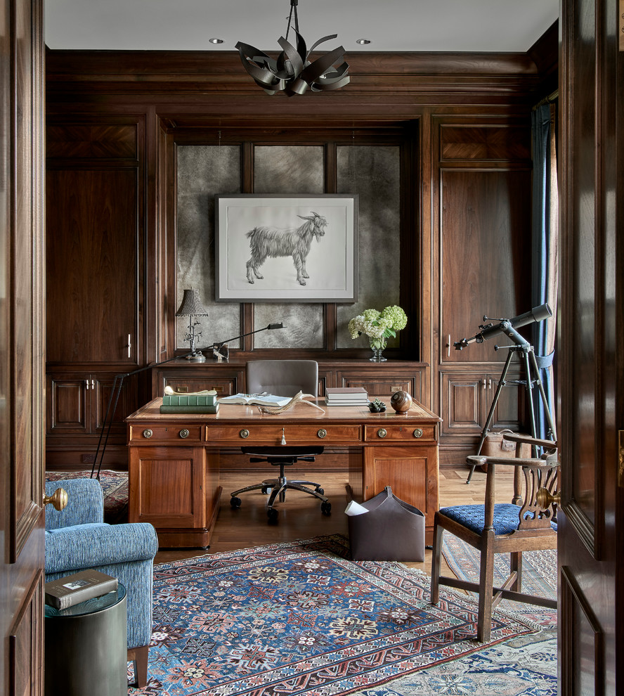 Imagen de despacho clásico grande sin chimenea con paredes marrones, suelo de madera clara y escritorio independiente