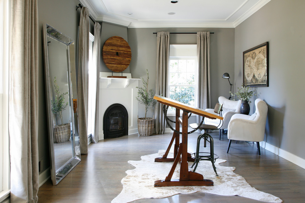 Large traditional home office in Atlanta with a reading nook, grey walls, medium hardwood flooring, a corner fireplace, a wooden fireplace surround, a freestanding desk and brown floors.