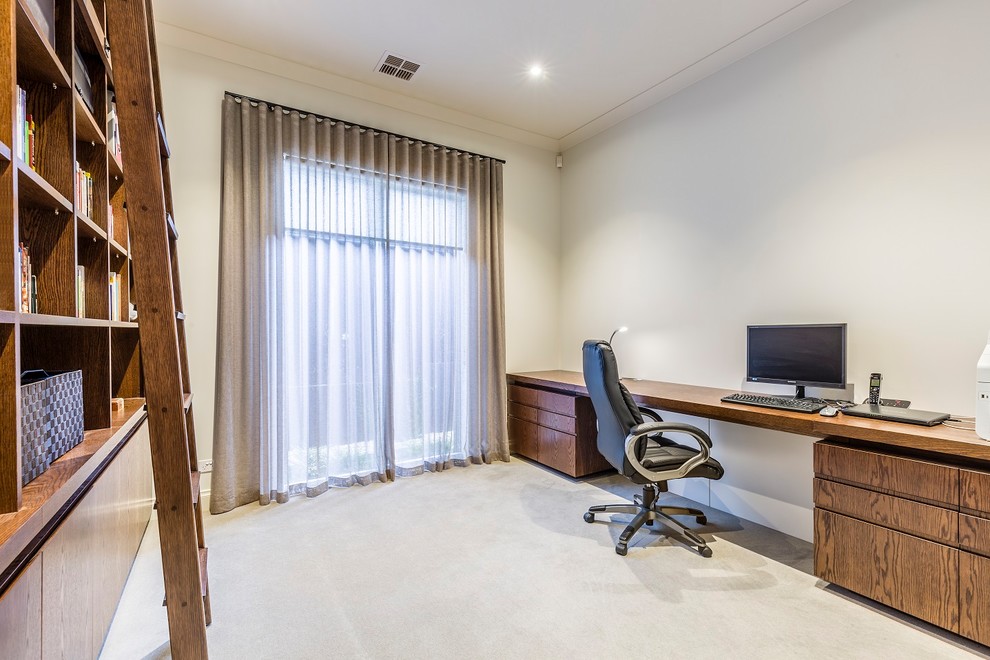 Mittelgroßes Modernes Arbeitszimmer ohne Kamin mit Arbeitsplatz, weißer Wandfarbe, Teppichboden, Einbau-Schreibtisch und grauem Boden in Melbourne