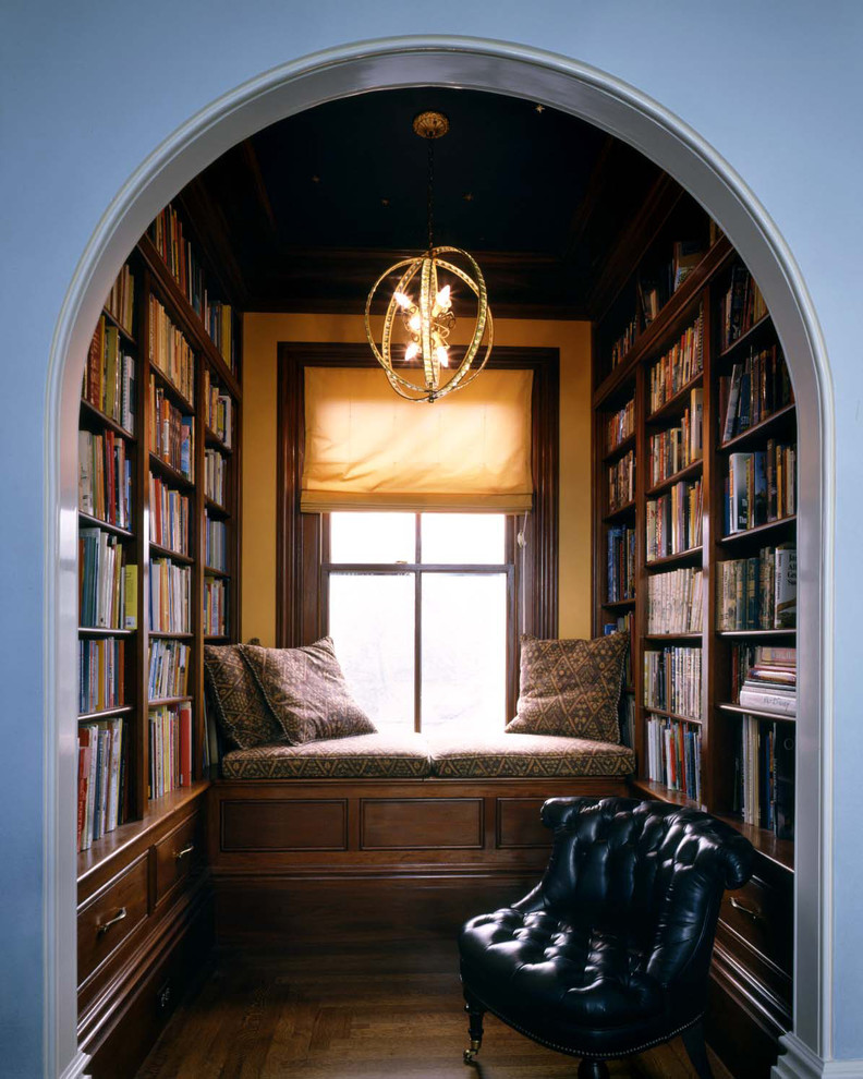 На фото: домашняя библиотека среднего размера в классическом стиле с темным паркетным полом и коричневым полом без камина