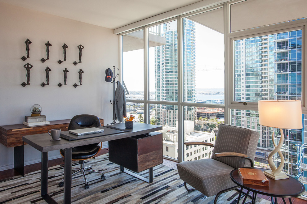 Mittelgroßes Modernes Arbeitszimmer mit Arbeitsplatz, beiger Wandfarbe, braunem Holzboden und freistehendem Schreibtisch in San Diego