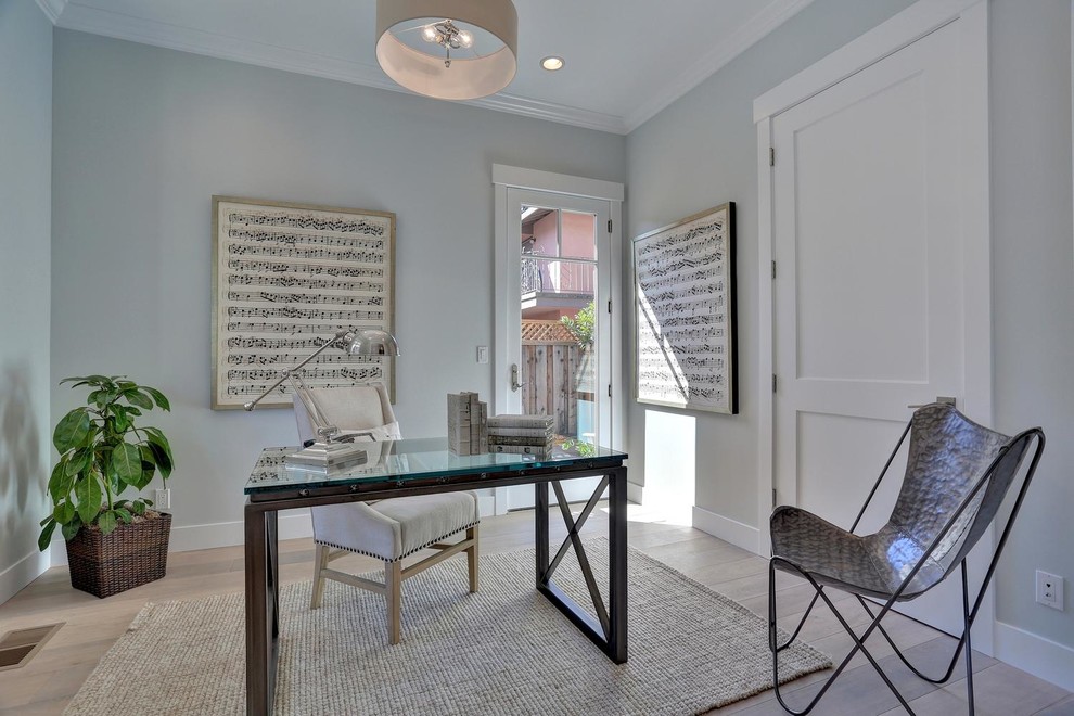 Ejemplo de despacho tradicional renovado de tamaño medio con paredes azules, suelo de madera clara y escritorio independiente